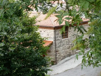 a stone building with a window and some trees at Apartamentos Rurales A Torre in Porqueira