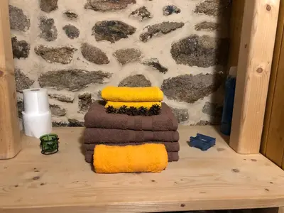 a pile of towels sitting on top of a wooden table at Apartamentos Rurales A Torre in Porqueira