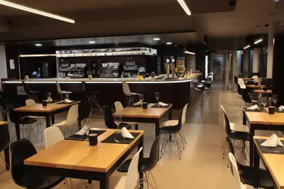 a restaurant with tables and chairs and a bar at Hotel San Cibrao in San Ciprián de Viñas
