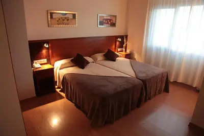 a bedroom with a large bed with a wooden headboard at Hotel San Cibrao in San Ciprián de Viñas