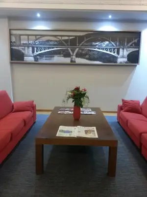 a living room with two red couches and a table at Hotel San Cibrao in San Ciprián de Viñas