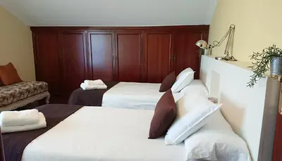 a hotel room with two beds and a couch at Casa Baixo O Castelo in Puente Caldelas