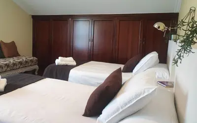 a hotel room with three beds and a couch at Casa Baixo O Castelo in Puente Caldelas