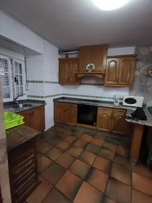 a kitchen with wooden cabinets and a tile floor at Casa Foz in Foz