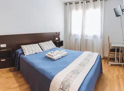 a bedroom with a bed with two towels on it at APARTAMENTOS CASAS NOVAS in Silleda