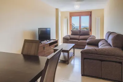 a living room with a couch and a tv at APARTAMENTOS CASAS NOVAS in Silleda