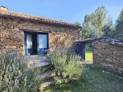 a stone house with a window in a yard at CASA COLOMBA in Santa Colomba de Somoza