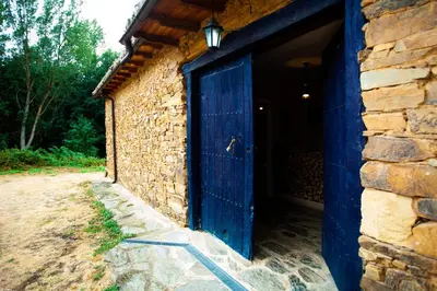 a blue door on the side of a stone building at CASA COLOMBA in Santa Colomba de Somoza