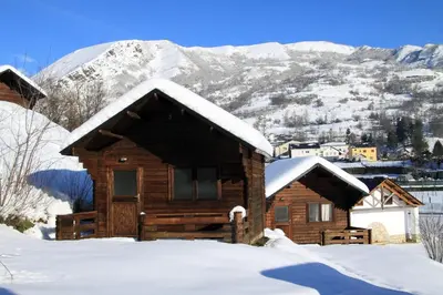 a barn covered in snow with a mountain in the background at Camping Laciana Natura in Villablino