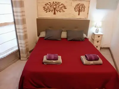 a bedroom with a large red bed with two pillows at Casita junto al Río en un entorno natural in Monforte de Lemos