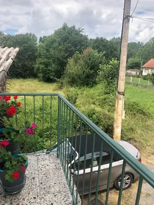a balcony with flowers in pots and a pole at Casita junto al Río en un entorno natural in Monforte de Lemos