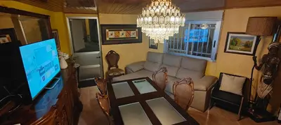 a living room with a couch and a tv and a chandelier at Casita junto al Río en un entorno natural in Monforte de Lemos