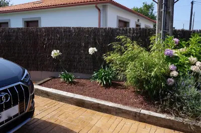 a fence in front of a house with flowers at Casa Asientos Boimorto in Boimorto