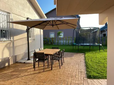 a table and chairs under an umbrella on a patio at Casa Asientos Boimorto in Boimorto