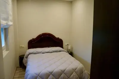 a small bedroom with a bed with a wooden headboard at Casa Asientos Boimorto in Boimorto