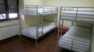 a room with three bunk beds and a window at El cordal de laciana in Caboalles de Abajo