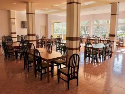 a dining room with tables and chairs and windows at Hotel Eumesa in Puentedeume