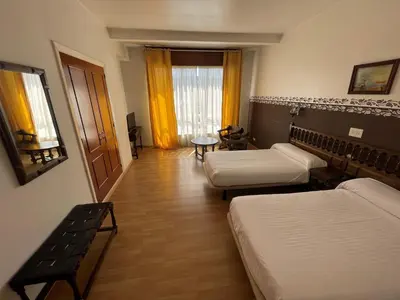 a hotel room with two beds and a table at Hotel Eumesa in Puentedeume