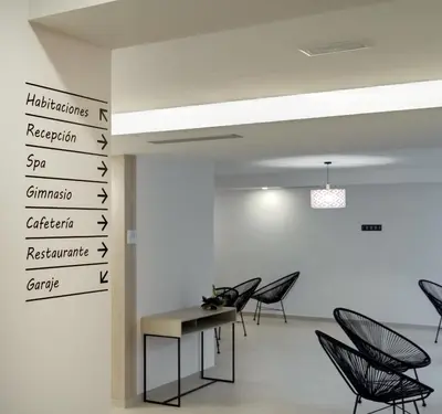 a room with chairs and a table and signs on the wall at Playa de Foz Hotel & Spa by gaiarooms in Foz