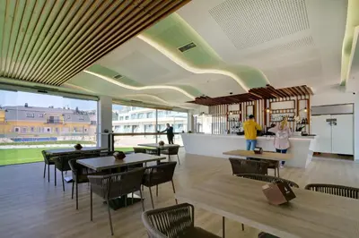 a restaurant with tables and chairs and a bar at Playa de Foz Hotel & Spa by gaiarooms in Foz