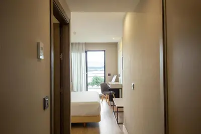 a bedroom with a bed and a desk and a window at Playa de Foz Hotel & Spa by gaiarooms in Foz