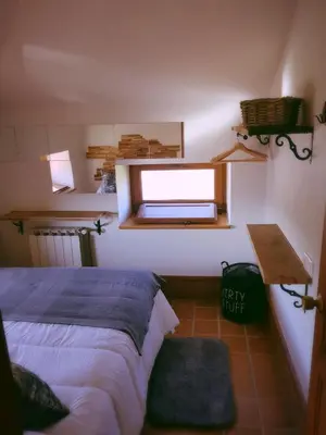 a bedroom with a bed and a mirror and a window at Elteixorural in Teijois