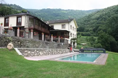a house and a swimming pool in front of a building at Casa Agudín in Cangas del Narcea