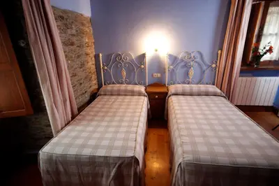 two beds sitting next to each other in a room at Casa Agudín in Cangas del Narcea