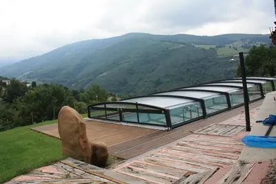 a glass building with a view of a mountain at Casa Agudín in Cangas del Narcea
