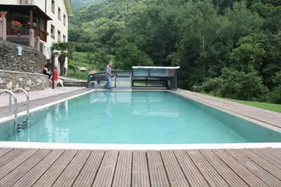 a man standing next to a large swimming pool at Casa Agudín in Cangas del Narcea