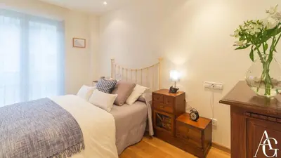 a bedroom with a bed and a dresser and a window at Apartamento Plaza de España in Ribadeo
