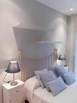 a bedroom with a bed with blue pillows at Apartamento Plaza de España in Ribadeo