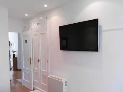 a living room with a flat screen tv on a wall at Apartamento Plaza de España in Ribadeo