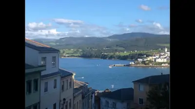 a view of a large body of water between buildings at Apartamento Plaza de España in Ribadeo