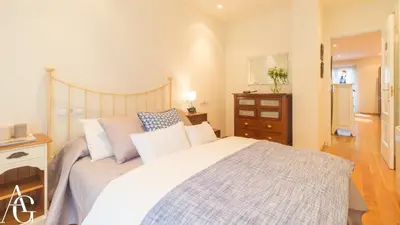 a bedroom with a large white bed and a dresser at Apartamento Plaza de España in Ribadeo