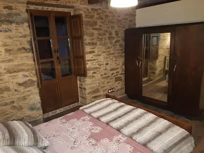 a bedroom with a bed and a large mirror at Apartamentos Rurales Casa Carmen in Pola de Allande