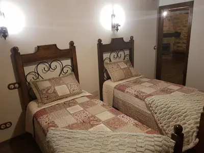 two beds sitting next to each other in a room at Apartamentos Rurales Casa Carmen in Pola de Allande