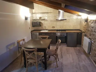 a kitchen with a wooden table and chairs at Apartamentos Rurales Casa Carmen in Pola de Allande