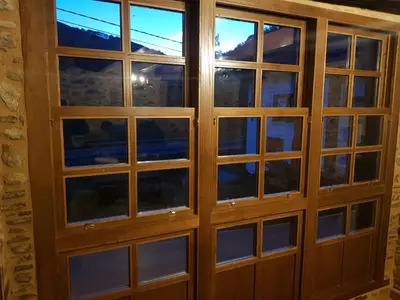 a wooden door with windows in a room at Apartamentos Rurales Casa Carmen in Pola de Allande