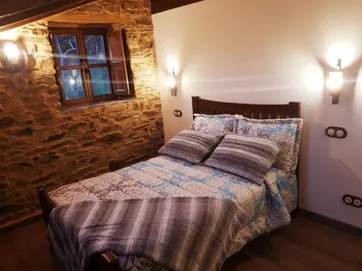 a bedroom with a bed with two pillows on it at Apartamentos Rurales Casa Carmen in Pola de Allande