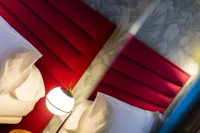a bedroom with two beds and a red wall at HOTEL JAVIER MONTERO in Ribadeo