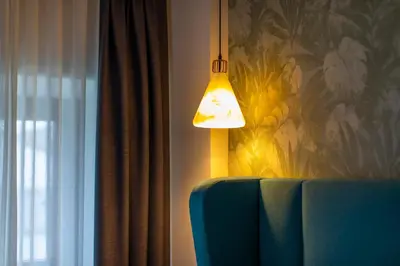 a lamp sitting on top of a table next to a curtain at HOTEL JAVIER MONTERO in Ribadeo