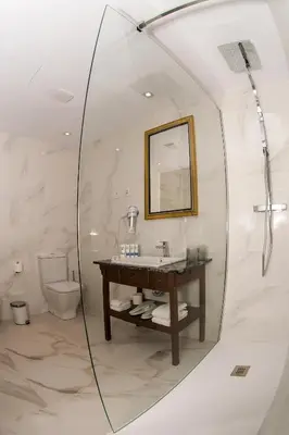 a bathroom with a mirror and a sink and a toilet at HOTEL JAVIER MONTERO in Ribadeo