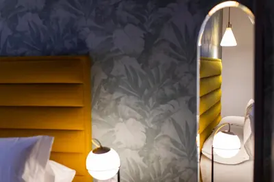 a bedroom with two lamps and a mirror at HOTEL JAVIER MONTERO in Ribadeo