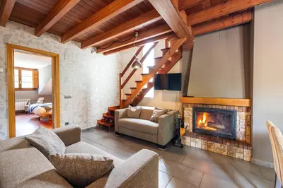 a living room with a couch and a fireplace at Apartamentos Casa Miño in Pola de Somiedo