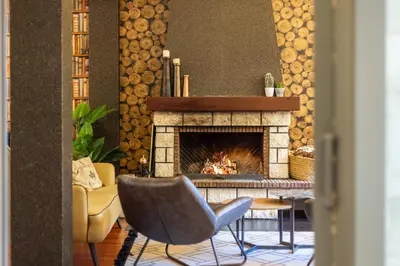 a living room with a fireplace and two chairs at Hotel Casa Miño in Pola de Somiedo