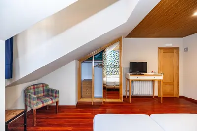 a living room with a couch and a table and a tv at Hotel Casa Miño in Pola de Somiedo