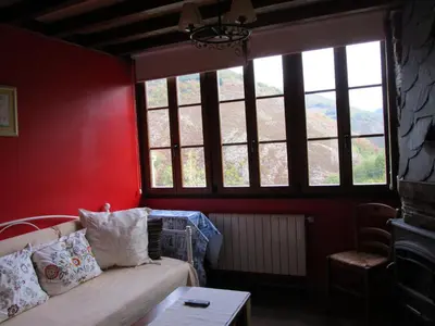 a living room with red walls and a couch and windows at Luna de Vilar in Vilarpescozo