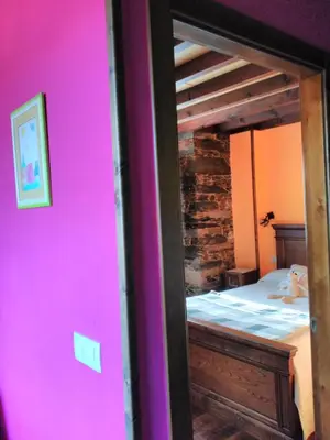 a bedroom with a bunk bed with a pink wall at Luna de Vilar in Vilarpescozo