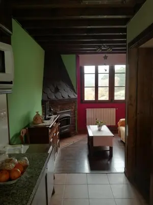 a kitchen with green and red walls and a table at Luna de Vilar in Vilarpescozo